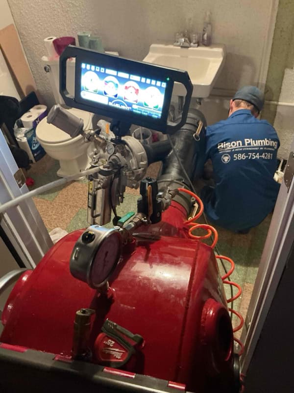 Bison Plumbing technician monitoring the CIPP pipe lining installation with inspection camera feed, Sterling Heights sewer repair